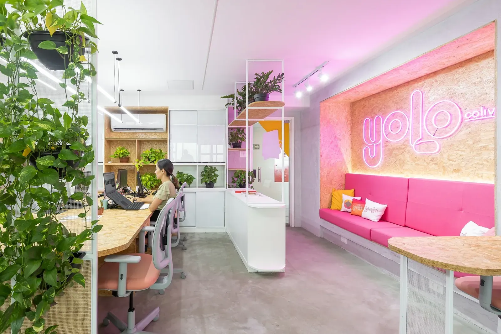 Coworking com estações compartilhadas, plantas e detalhes rosados