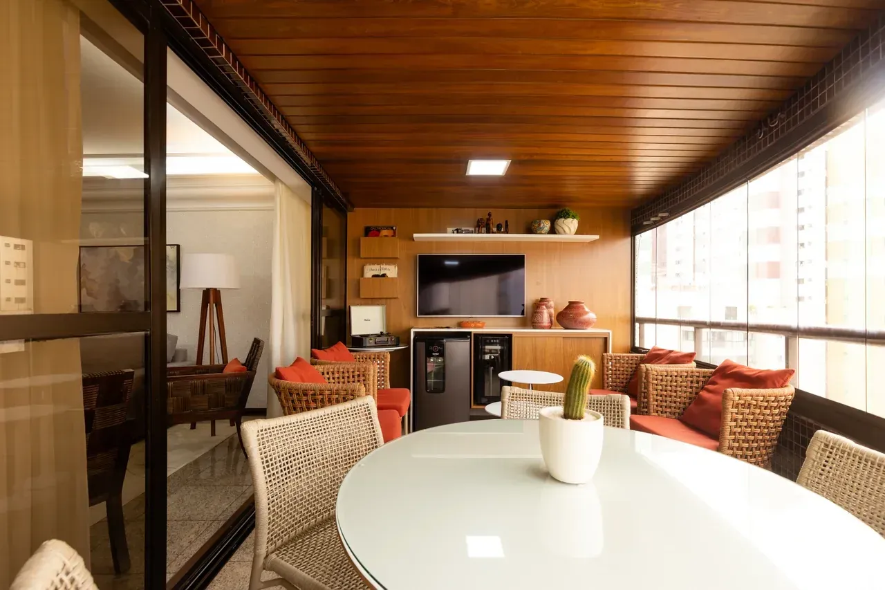Varanda gourmet com bancada e mesa de jantar